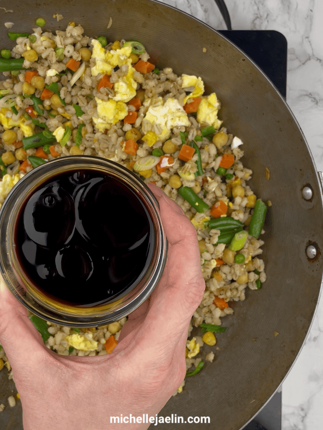 soy sauces, sesame oil and rice vinegar being added to barley fried rice recipe