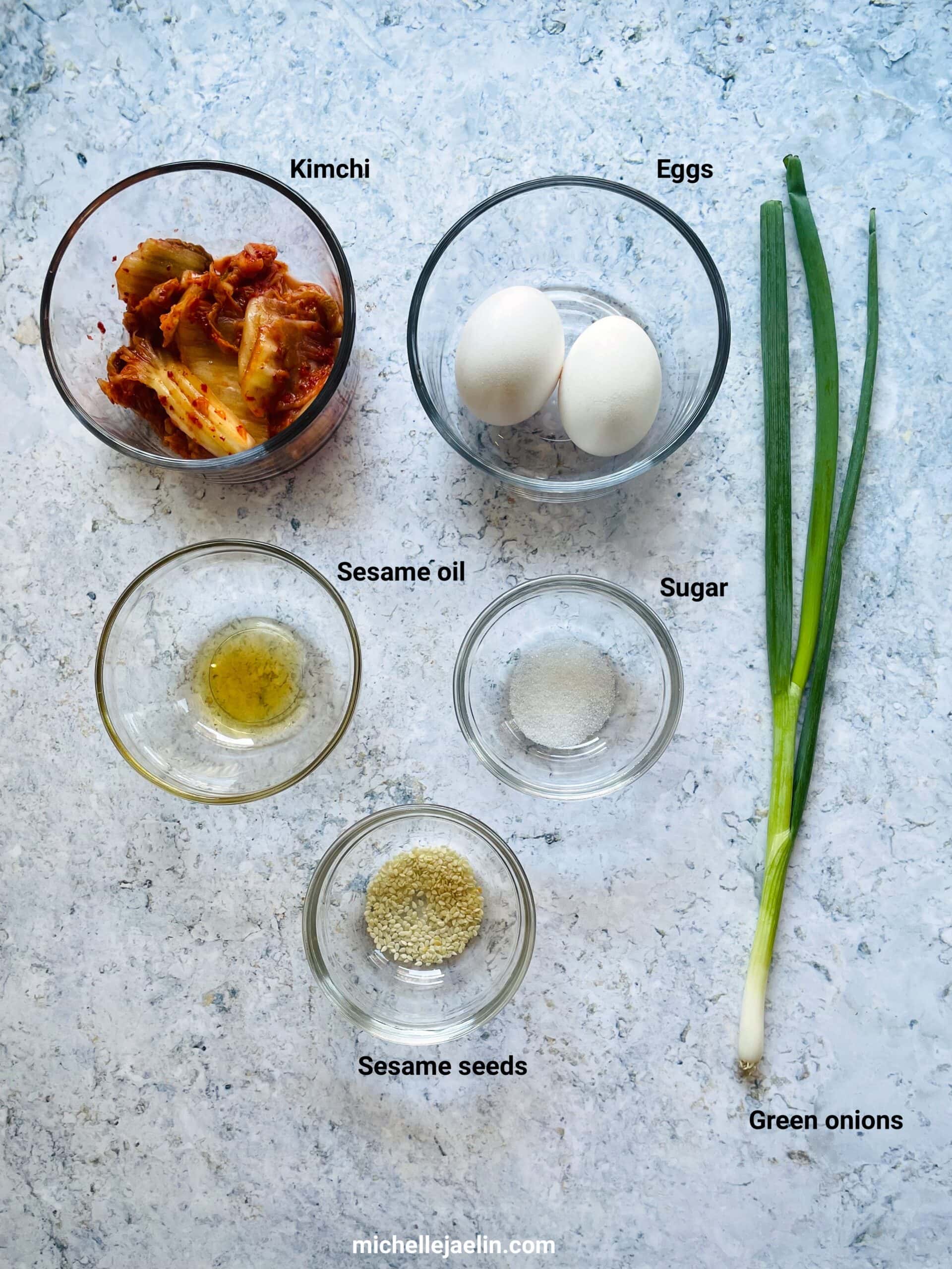 Recipe ingredients: kimchi, eggs, sesame oil, sugar, green onions and sesame seeds.