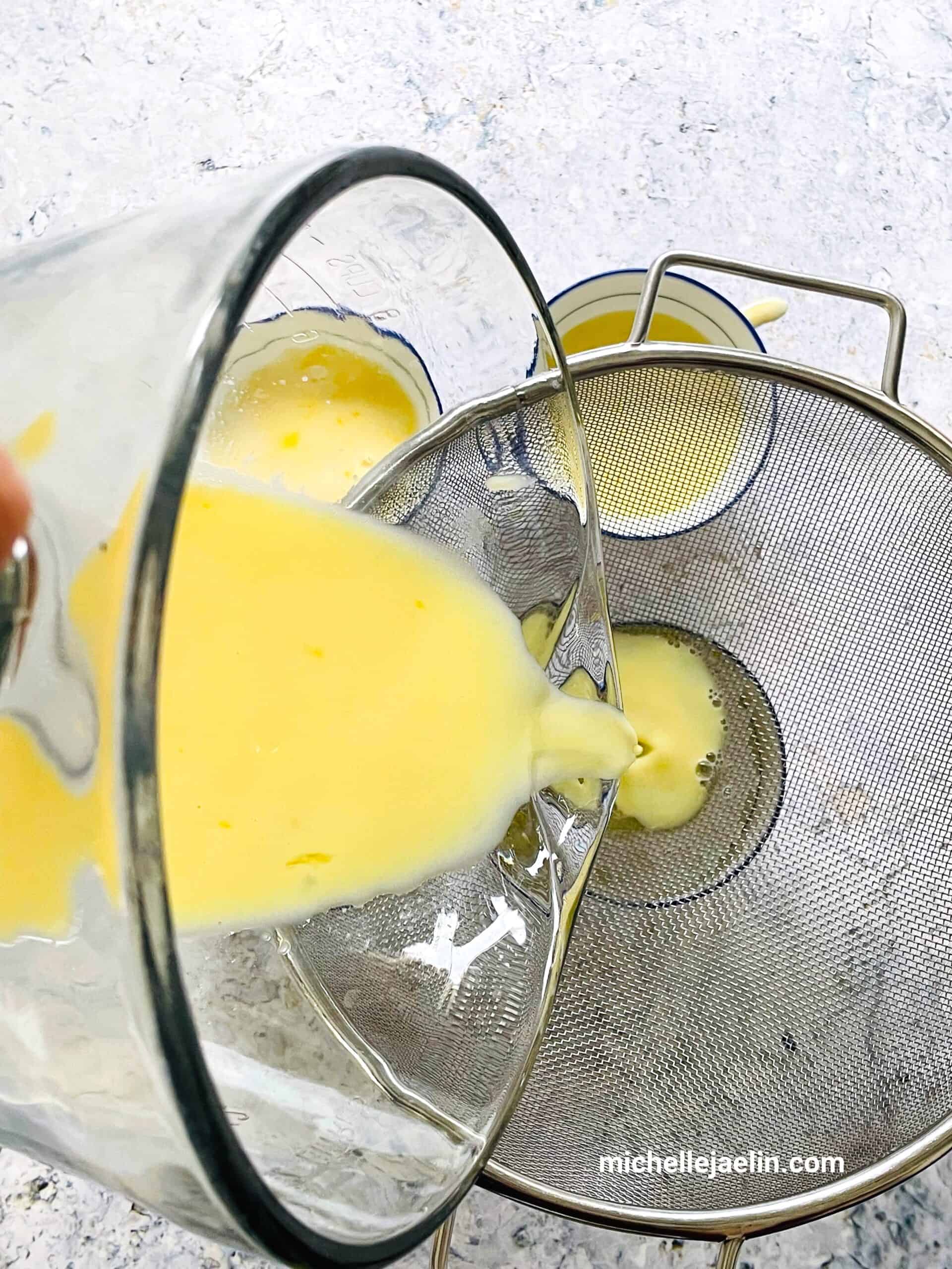 Egg mixture being poured into small bowls/ramekins over a sieve.
