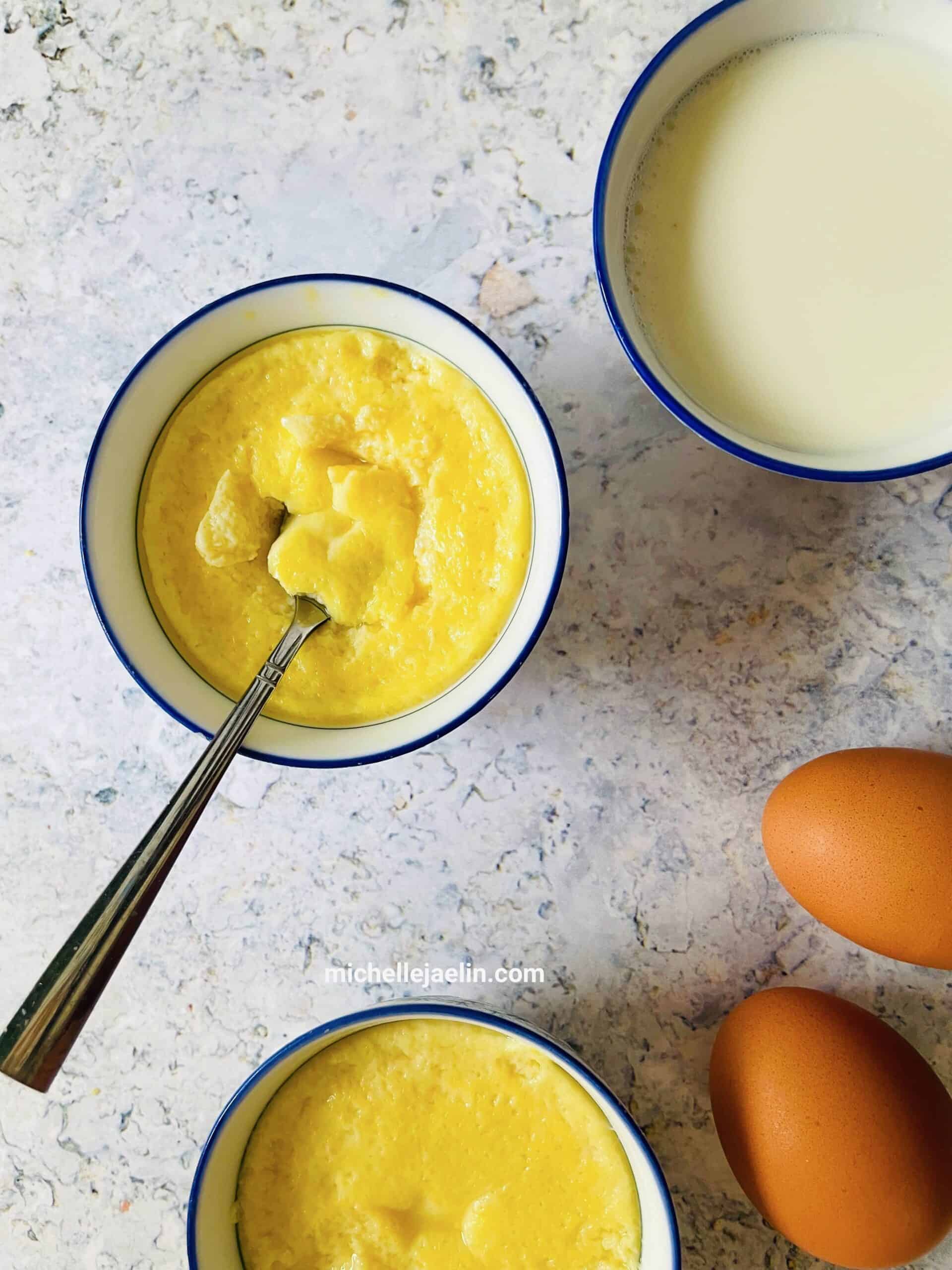 Chinese egg custard dessert recipe in 2 bowls with ingredients milk and brown eggs on the side