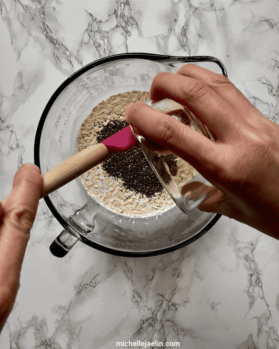Honey or maple syrup being poured into a large bowl with rolled chia seeds, oats, yogurt and milk