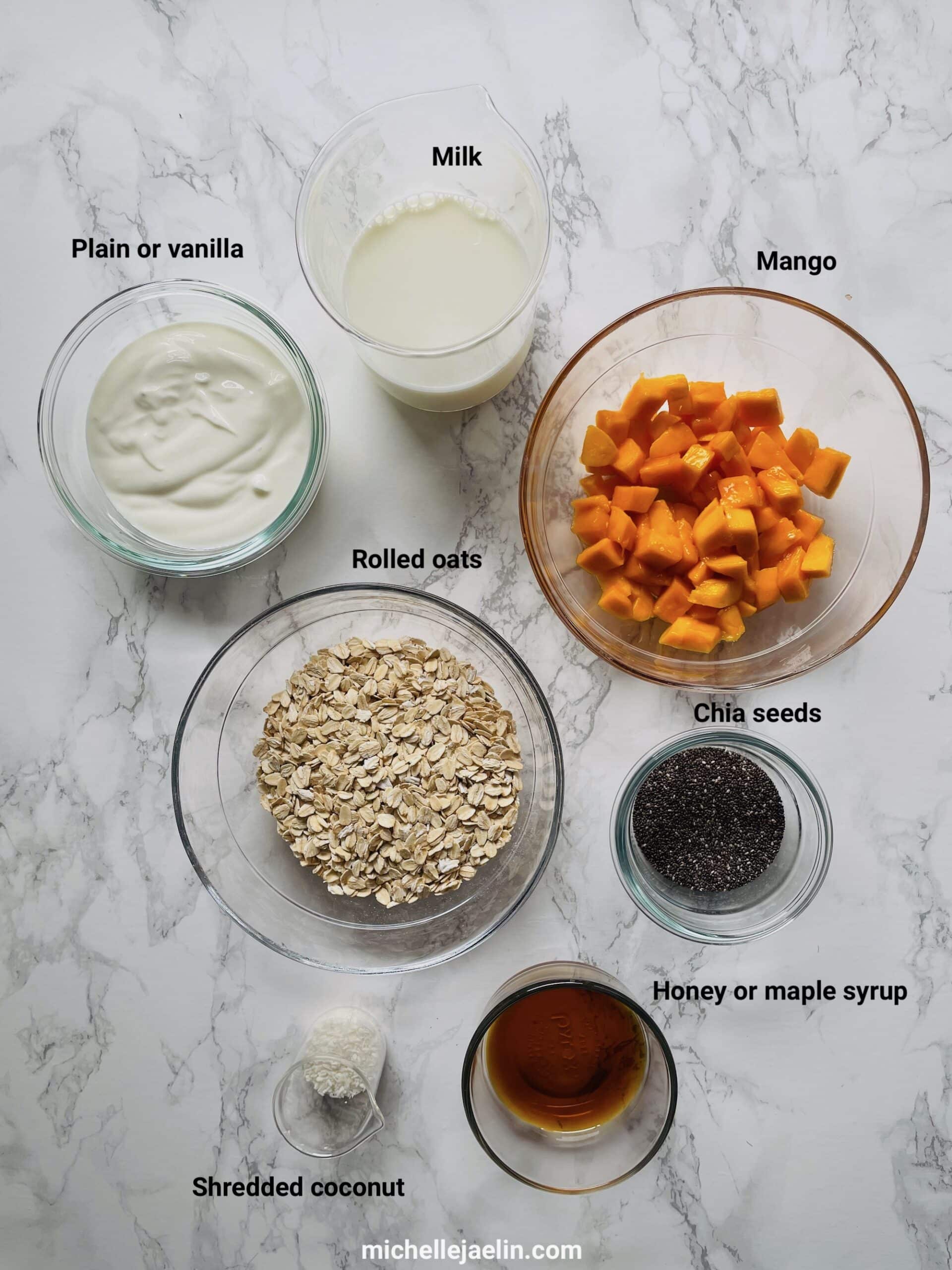 Ingredients in overnight oats with mango: yogurt, milk, rolled oats, chia seeds, shredded coconut, honey and mango
