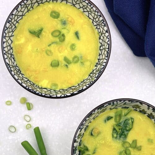 2 bowls of healthy vegetarian egg drop soup (gluten-free) with chopped green onions on the side