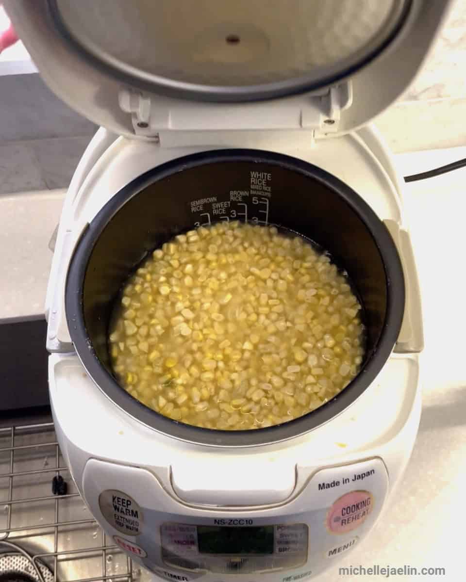 rice, corn and water in rice cooker