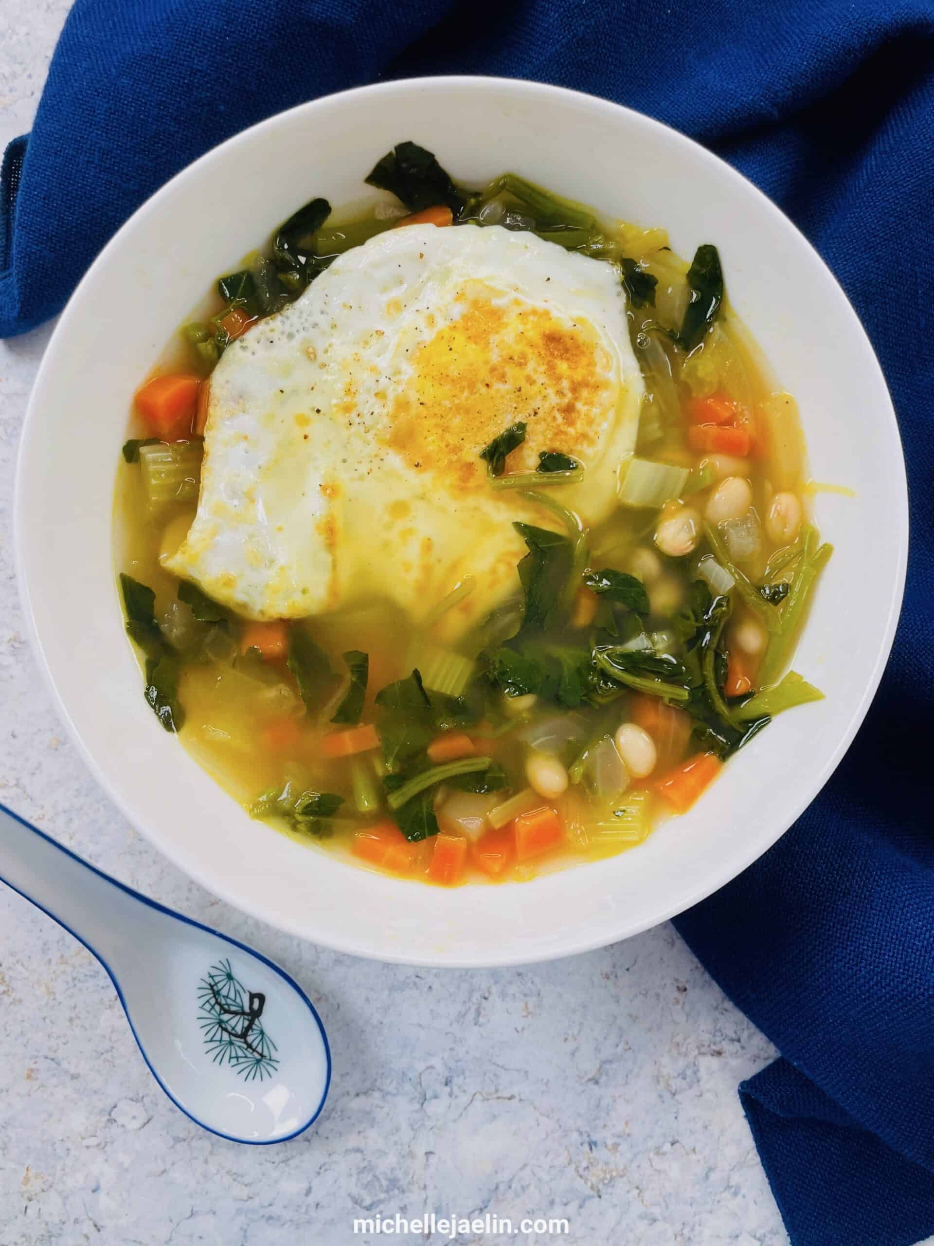 Beans and Watercress Greens Soup in a bowl with a spoon in bottom left hand corner
