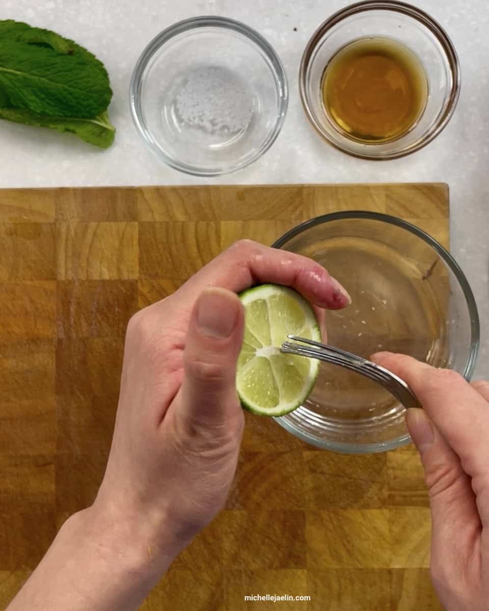 lime juice being squeezed into a small bowl